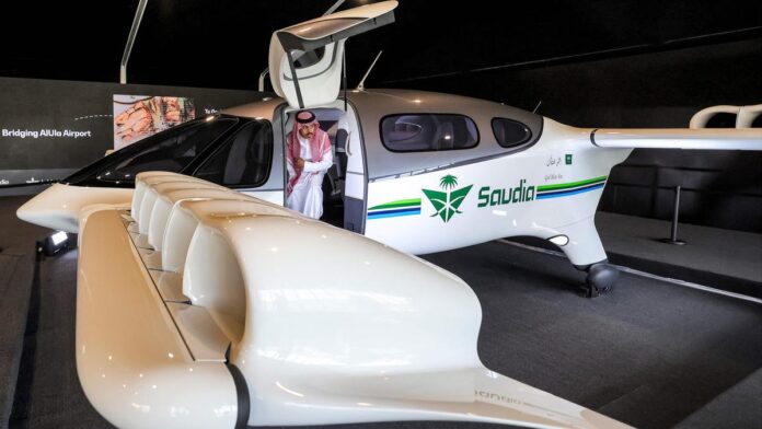 A visitor inspects a Saudia Airlines electric Vertical Take-Off and Landing (eVTOL) Lilium jet displayed during the Global Logistics Forum in Riyadh on October 14, 2024. | Photo Credit: AFP