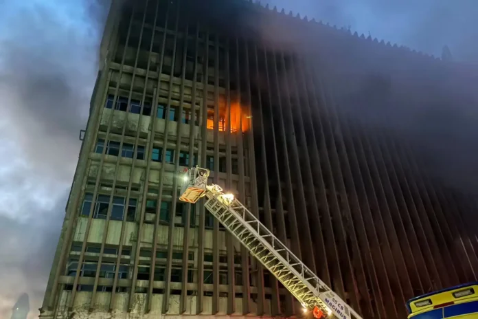 Firefighters work to extinguish flames at Cairo's Ramses Central Exchange as thick smoke billows from the telecommunications building